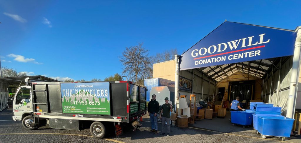 The Recyclers crew unloading furniture and lamps from their truck at the Goodwill Donation Center